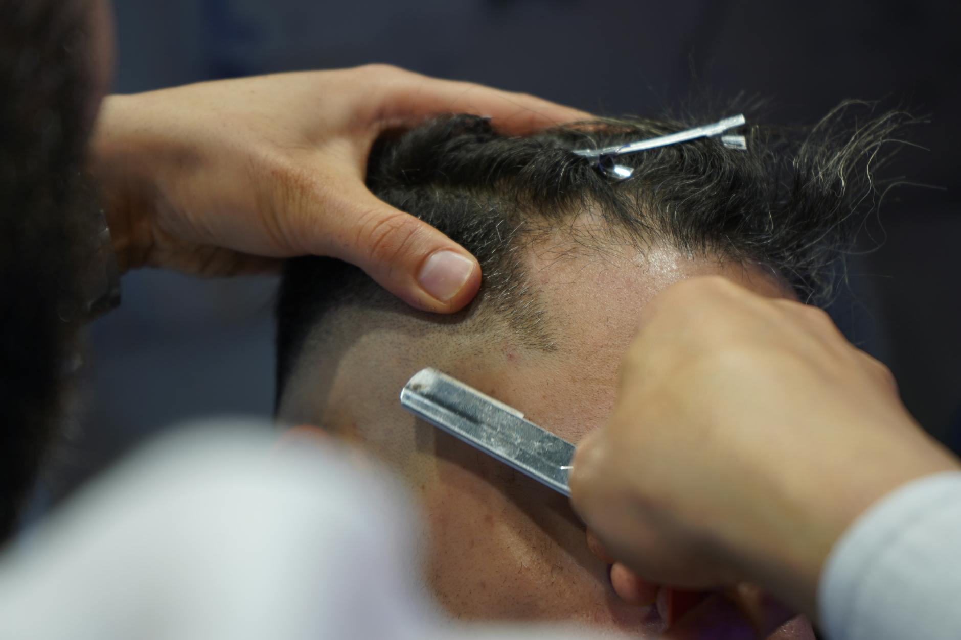 Barber performing a precision haircut on a client